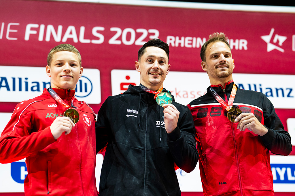 Siegerehrung mit drei Männern, die ihre Medaillen präsentieren
