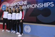 Das Deutsche Team, bestehend aus 5 Personen, stehen vor dem Schriftzug "Trampoline World Championchips)