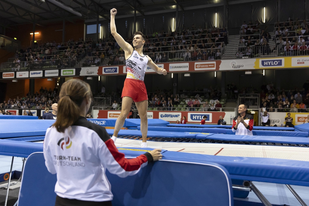 Der Sportler Mathias Schuldt jubelt nach einer erfolgreichen Kür auf dem Trampolin.