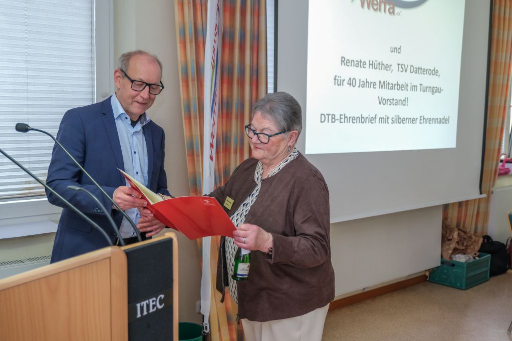 Ein Mann überreichte einer Frau eine Ehrung.