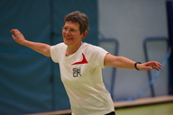 Eine ältere Frau macht eine Bewegung und lacht.