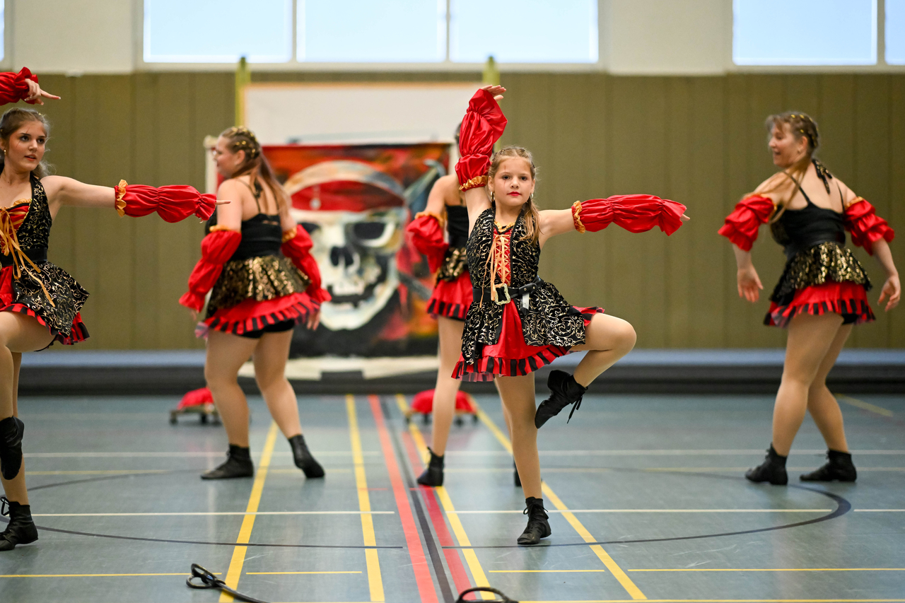 Eine junge Tanzgruppe in Kostümen präsentiert ihre Show.