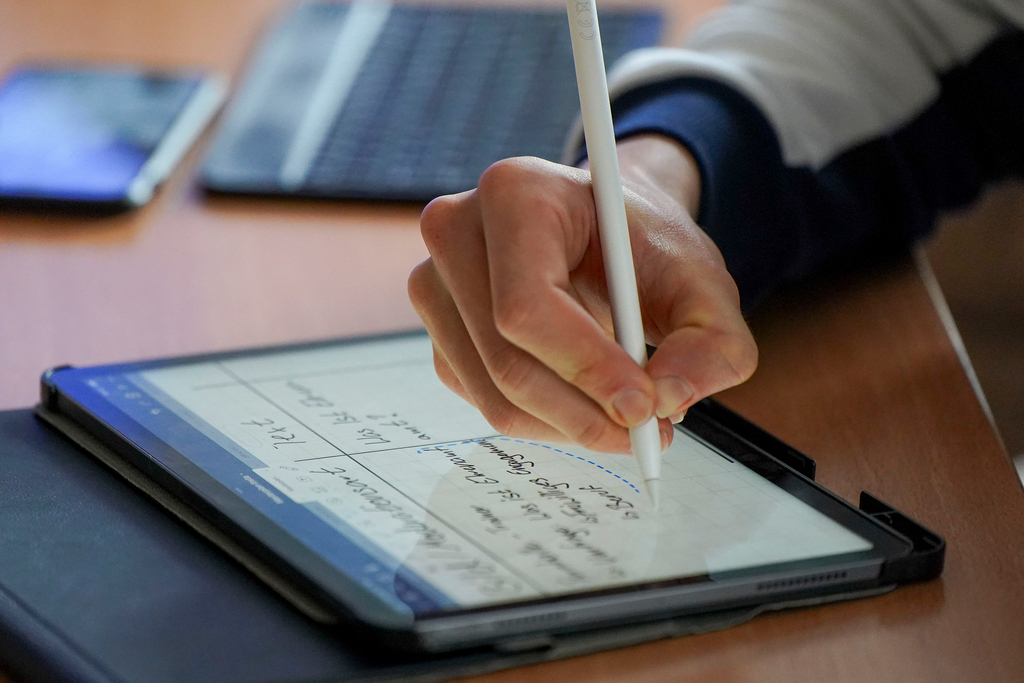 Eine Hand, die einen Stift hält und etwas aufschreibt
