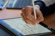 Eine Hand, die einen Stift hält und etwas aufschreibt