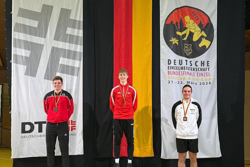 Drei Männer stehen auf einem Podest