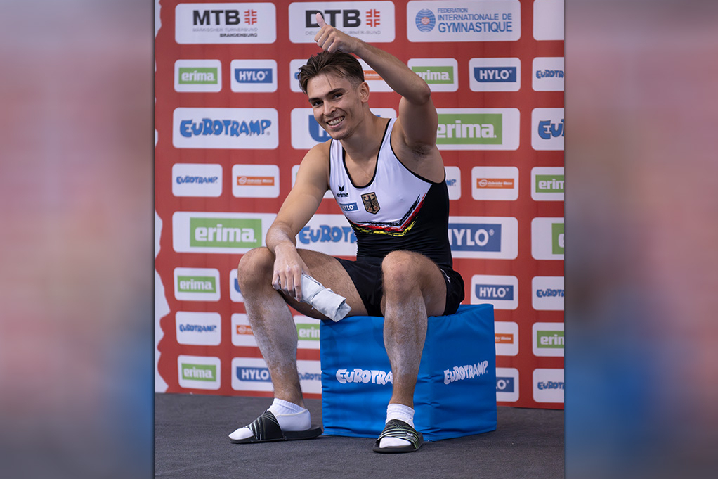 Trampolinturner lächelt und hält den Daumen hoch.