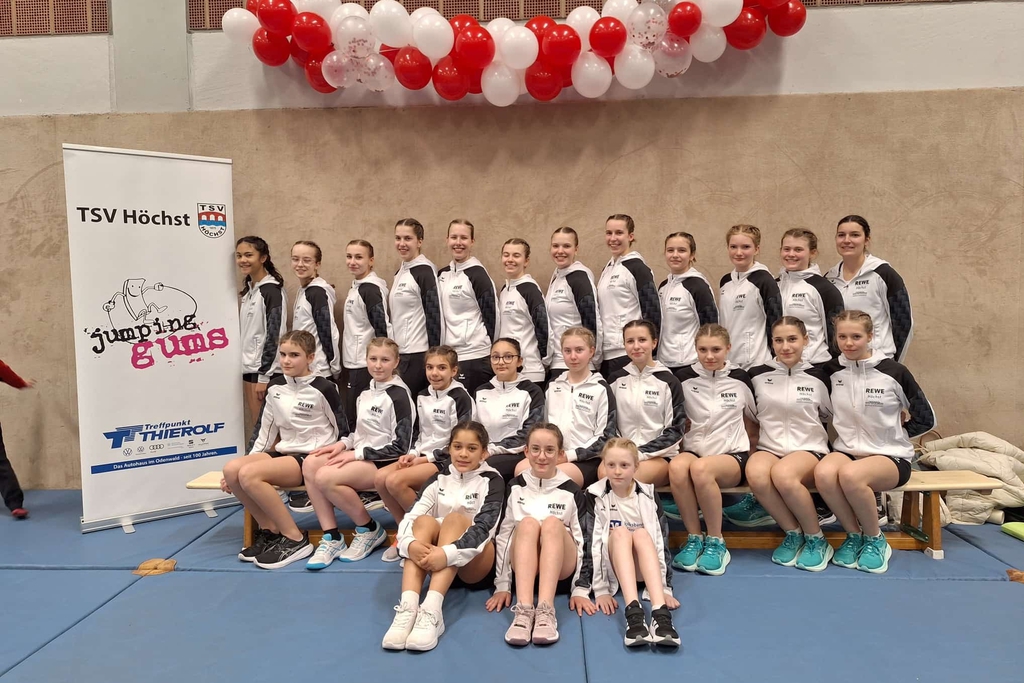 Viele Personen posieren auf einem Podest bei der Siegerehrung.