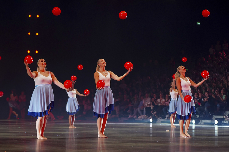 Eine Showgruppe präsentiert eine Vorführung mit Bällen.