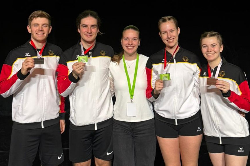 Fünf Personen zeigen ihre Medaille.