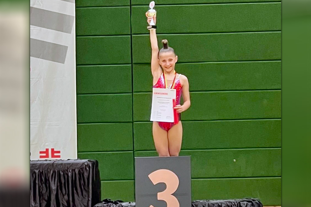 Gymnastin streckt Pokal in die Höhe.