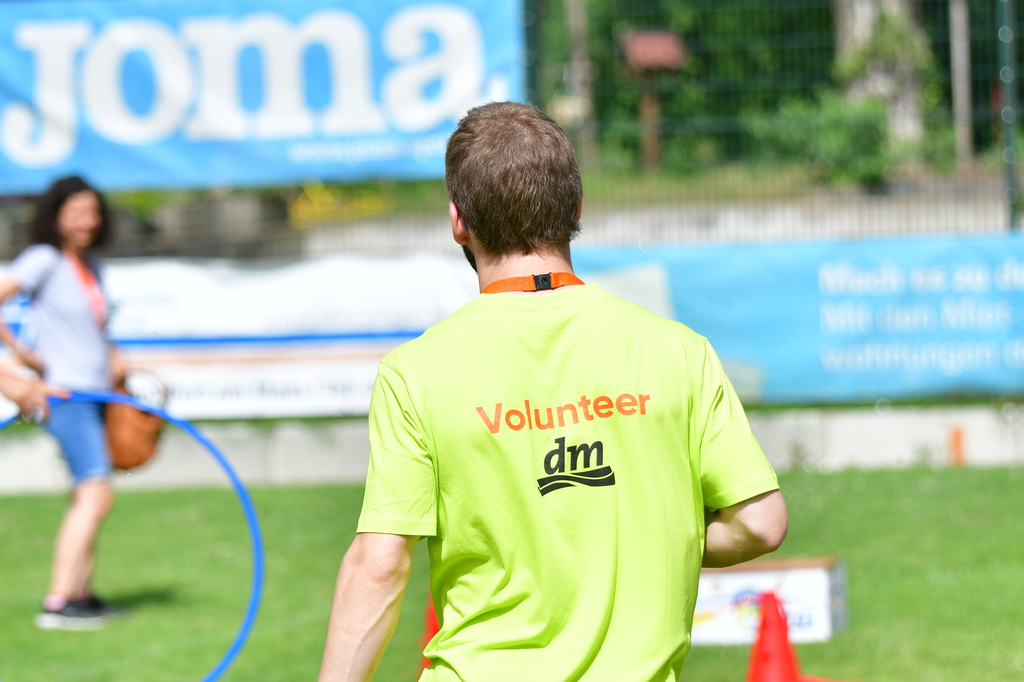 Ein junger Mann von hinten mit der T-Shirt Aufschrift "Volunteer".