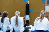 Eine Gruppe sitzt in einem Sitzkreis in einer Turnhalle.