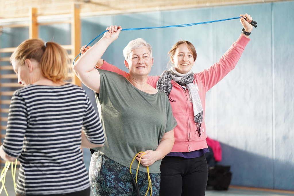 Zwei Frauen machen gemeinsam eine Übung mit einem Seil.