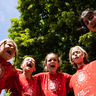 Kinder stehen in einem Kreis, legen die Arme umeinander und rufen einen gemeinsamen Spruch.