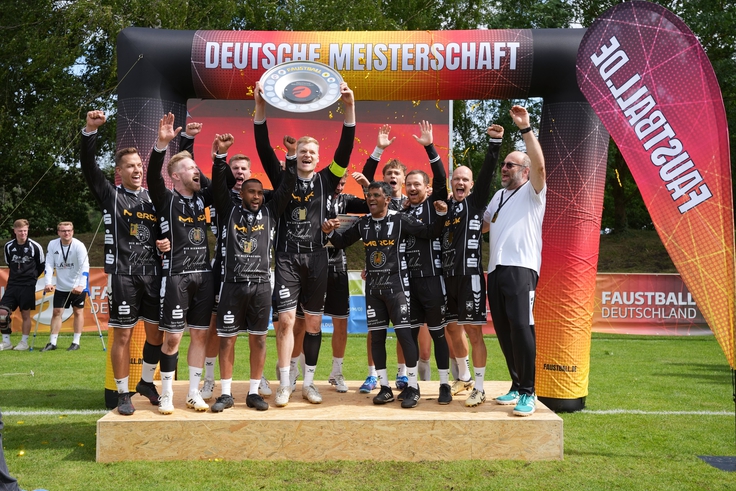 Ein Team freut sich mit Meisterschale über den Sieg.