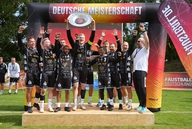 Ein Team freut sich mit Meisterschale über den Sieg.