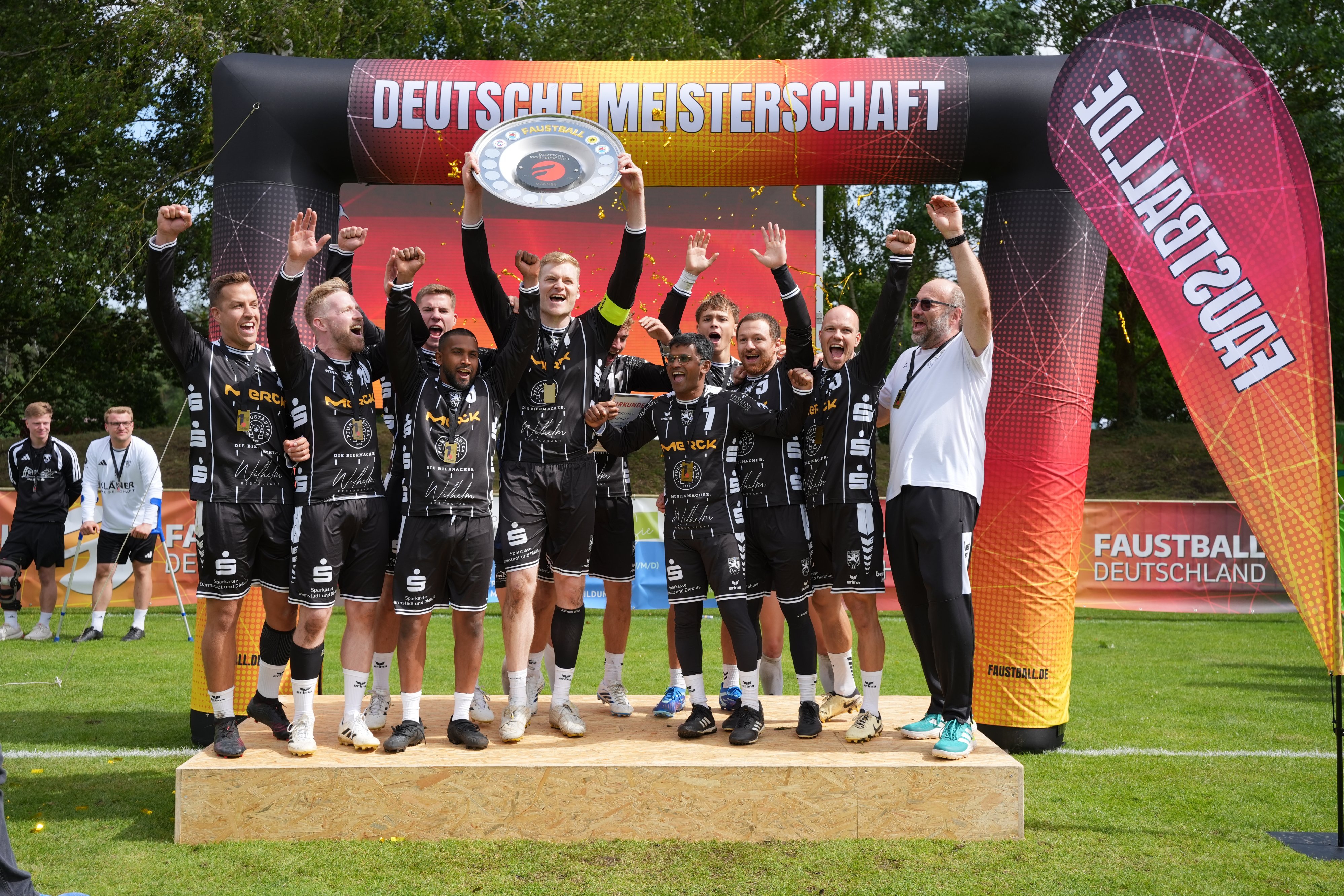 Ein Team freut sich mit Meisterschale über den Sieg.