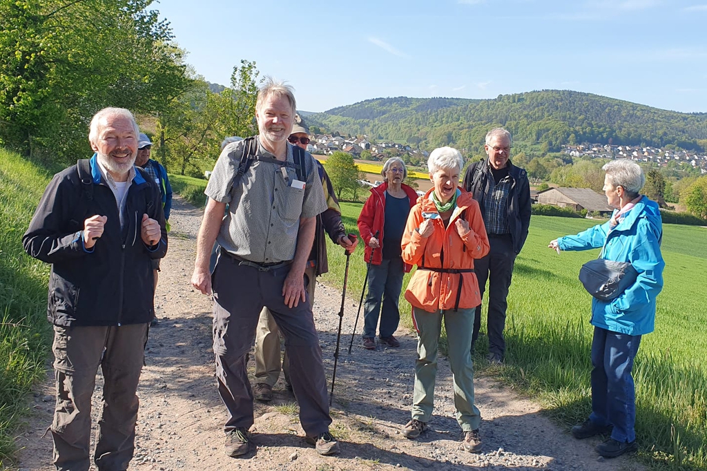Mehrere Personen wandern im Grünen.