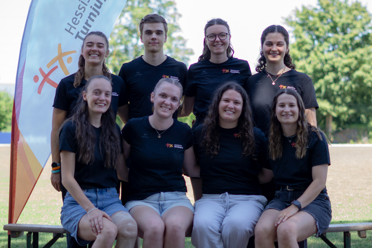 Acht junge Menschen posieren für ein Gruppenfoto