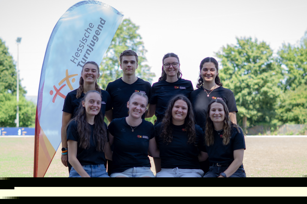 Acht junge Menschen posieren für ein Gruppenfoto