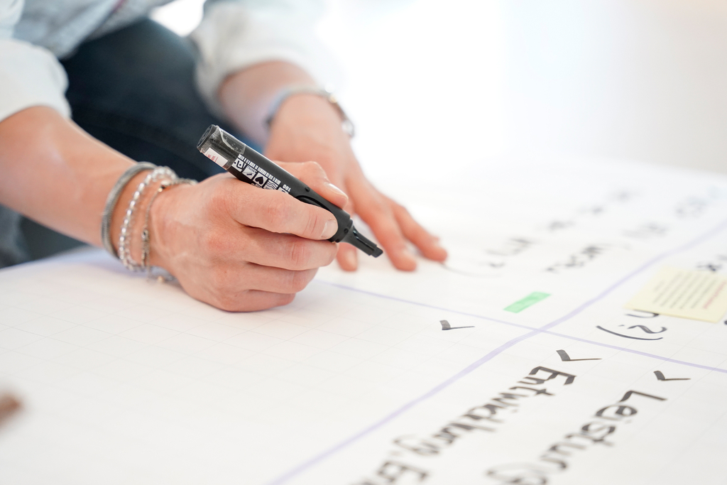 Eine Frau schreibt auf ein Plakat.