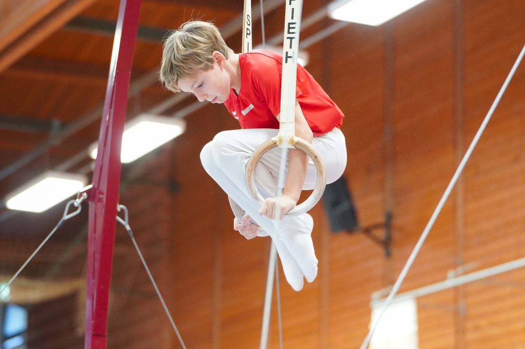 Junger Turner im Stütz an den Ringen