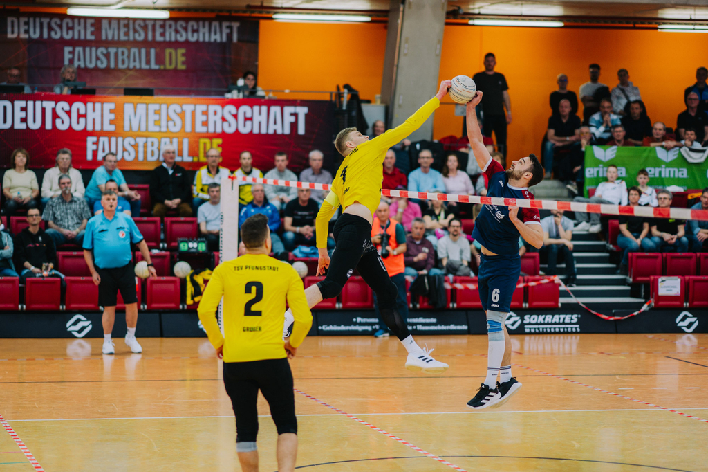 Zwei gegnerische Spieler treffen beide über dem Band den Ball