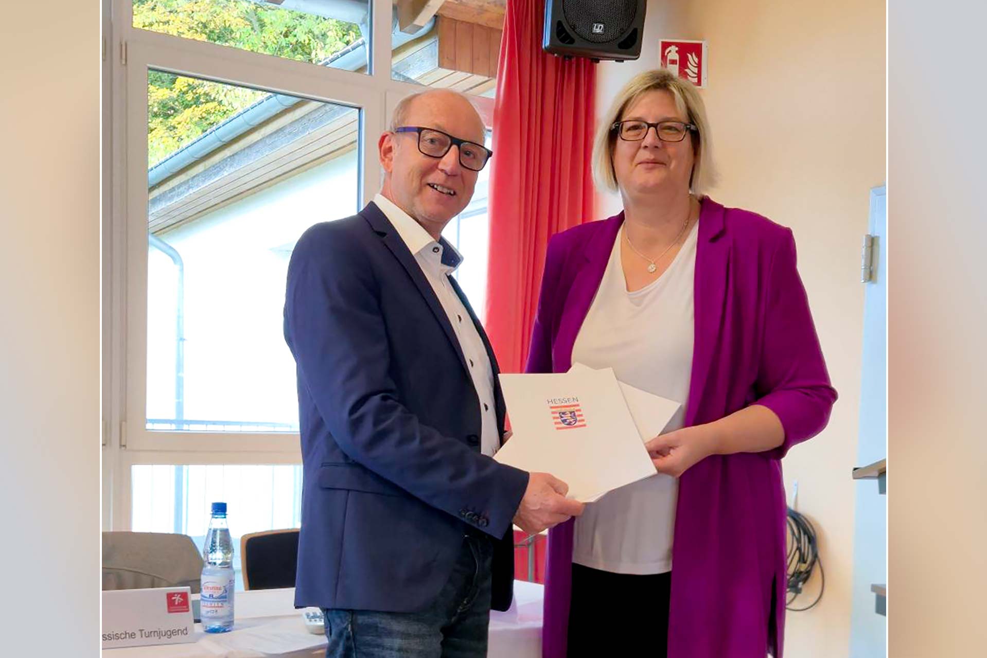 Zwei Personen halten gemeinsam die Urkunden