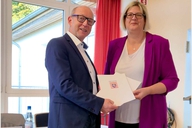 Zwei Personen halten gemeinsam die Urkunden