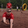 Ein Mann wirft sich auf einem Spielfeld nach einem Tennisring.