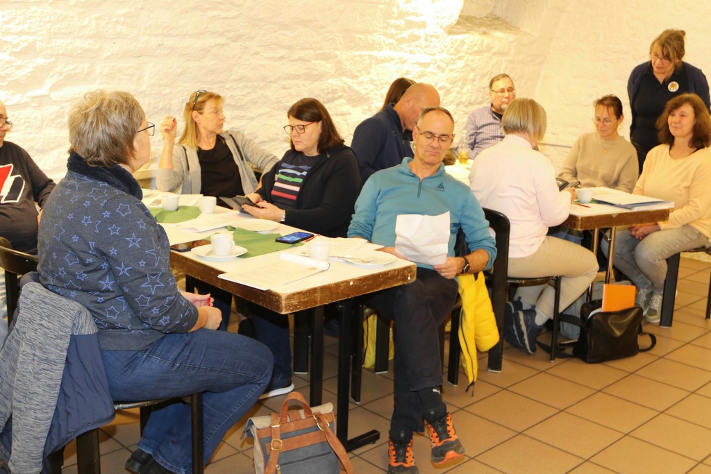 Mehrere Personen sitzen zusammen an einem Tisch.