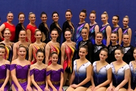 Gymnastinnen in Kostümen posieren für ein Gruppenfoto.