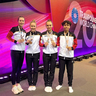 Vier jugendliche stehen neben einander mit ihren Medaillen in der Hand vor der LED-Wand "Trampoline World Championships"