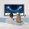 Ein Pärchen sitzt auf einem Sofa vor dem Fernsehen. 