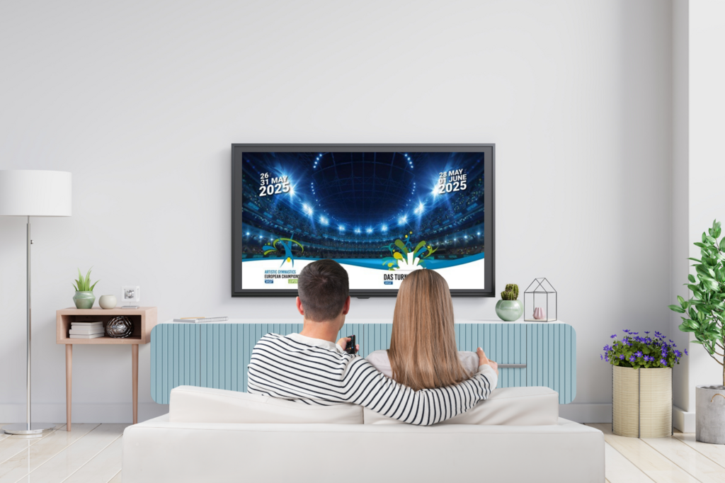Ein Pärchen sitzt auf einem Sofa vor dem Fernsehen. 