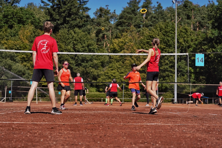 Eine Gruppe spielt auf einer Anlage Ringtennis.