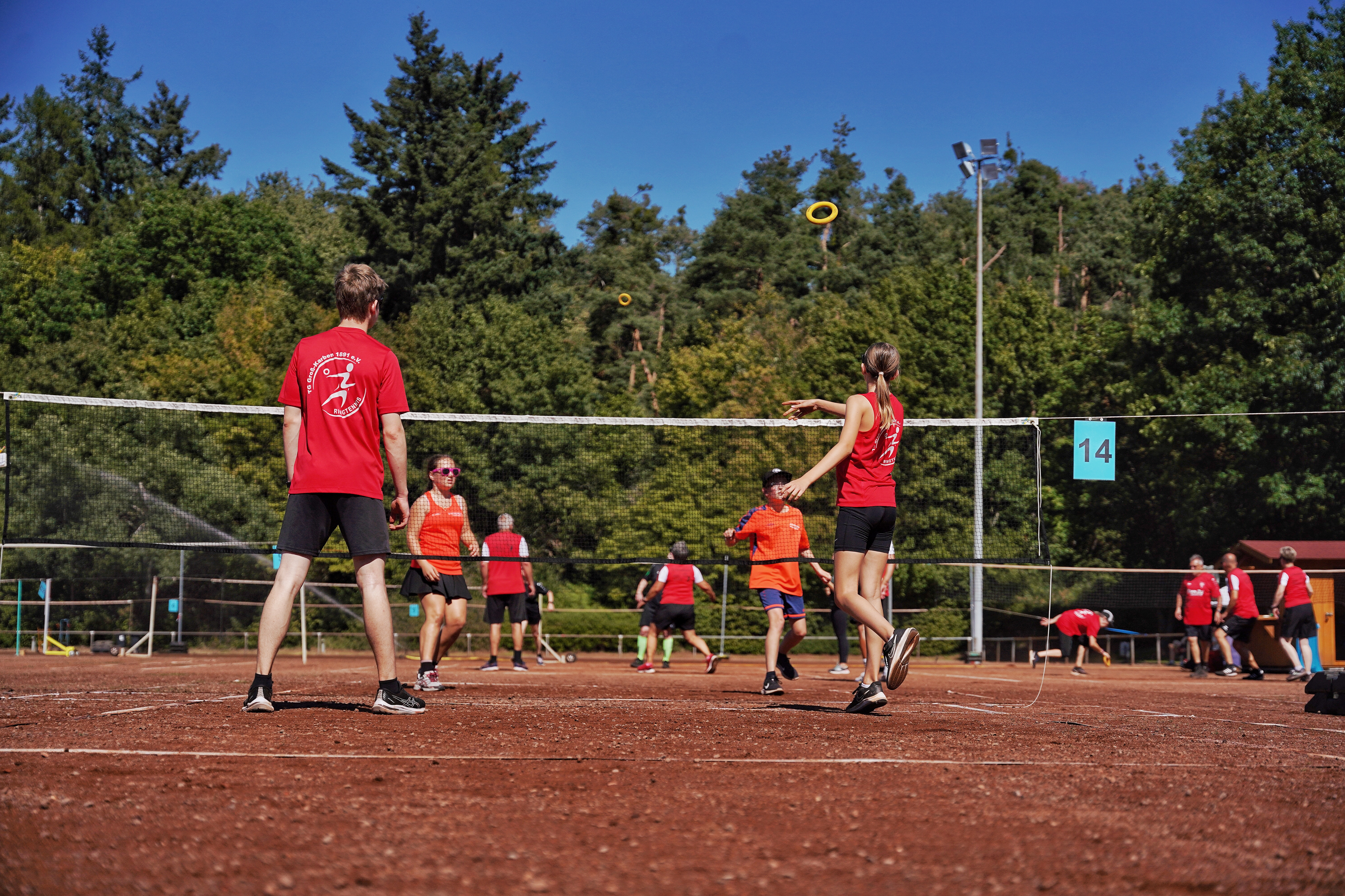 Eine Gruppe spielt auf einer Anlage Ringtennis.