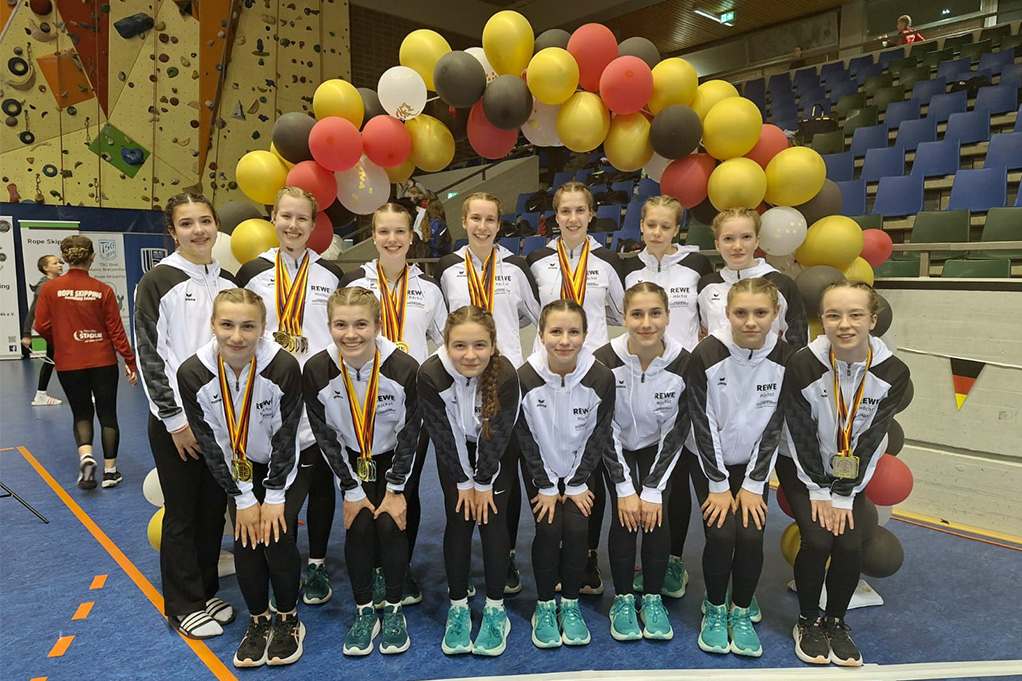 Ein Team posiert vor Luftballons. 