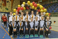 Ein Team posiert vor Luftballons. 