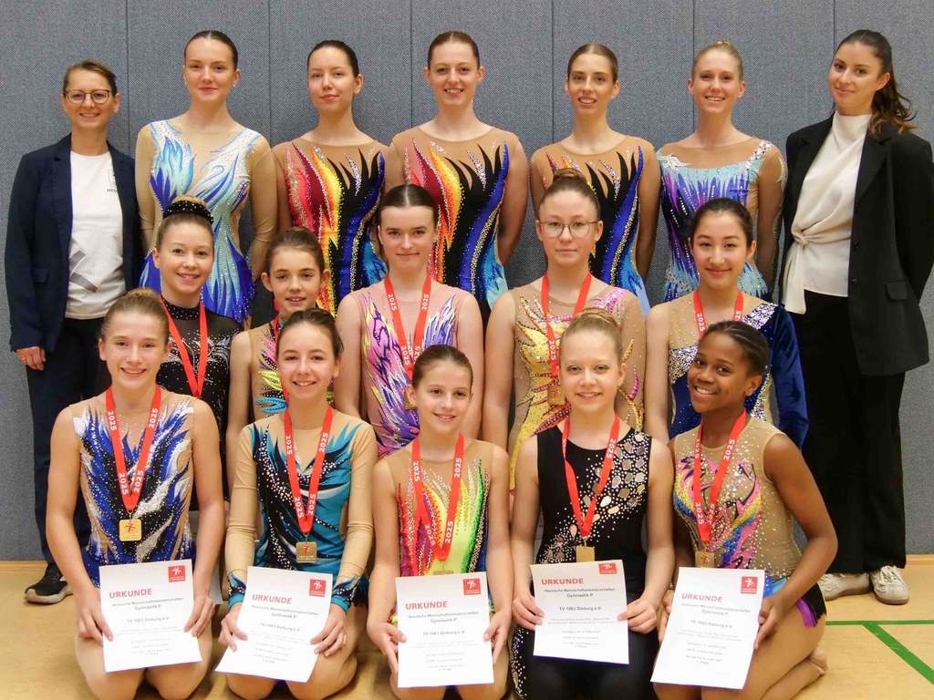 In drei Reihen präsentieren sich die Gymnastinnen mit ihren Medaillen