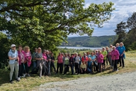 Viele Wanderinnen posieren unter einem Baum für ein Foto.