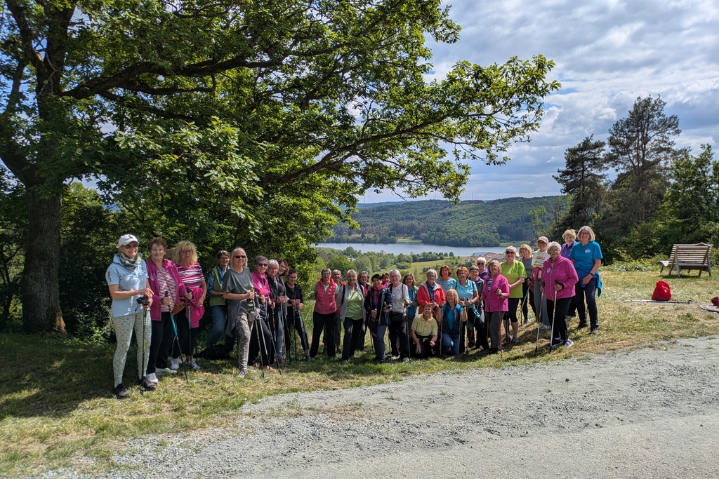 Viele Wanderinnen posieren unter einem Baum für ein Foto.
