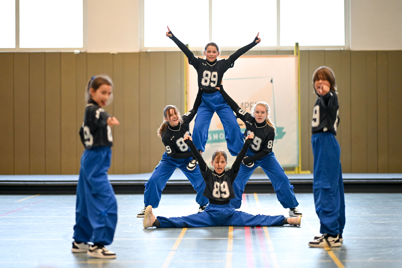 Eine Tanzgruppe in blauen Hosen und schwarzen T-Shirts präsentiert ihre Show.