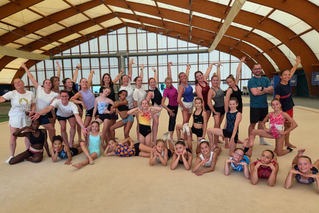 Viele Turnerinnen und Trainer sowie Trainerinnen haben sich für ein Gruppenbild aufgestellt.