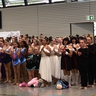 Mehrere Tanzgruppen stehen aufgereiht nebeneinander.