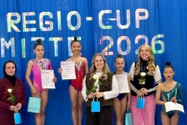 Gymnastinnen posieren auf einem Podest.