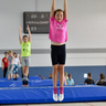 Mehrere Kinder springen nacheinander auf einer Trampolinbahn.