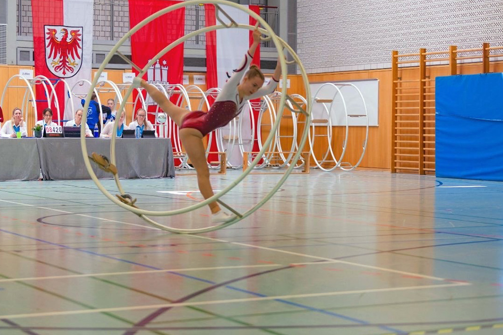 Mädchen turnt mit Rhönrad