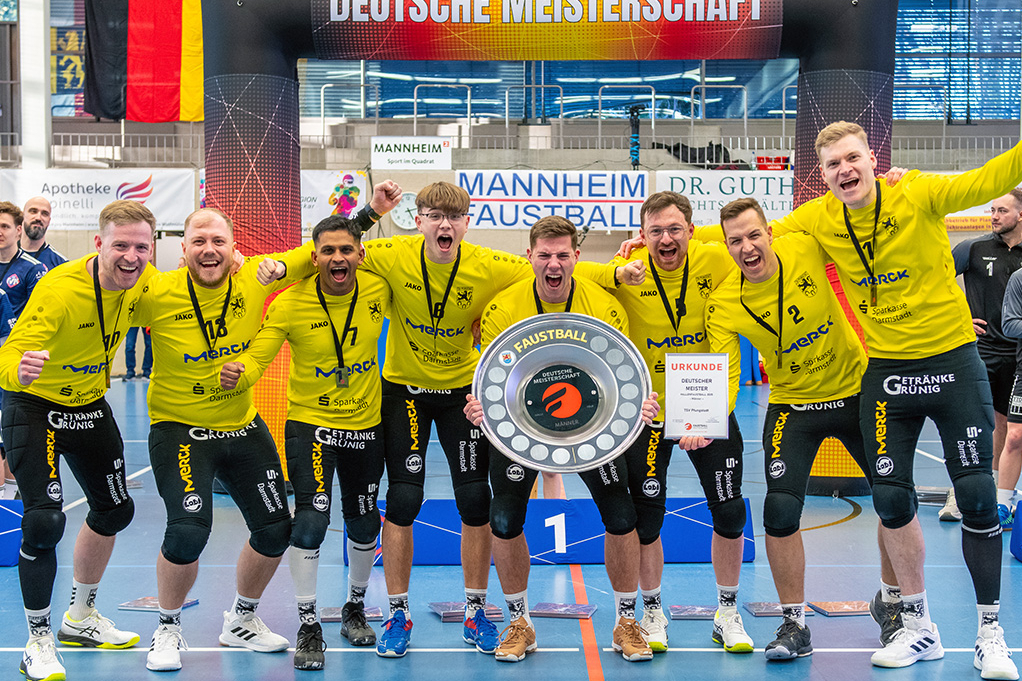 Die Mannschaft steht mit der Siegerschale dicht zusammen und jubelt zur Kamera