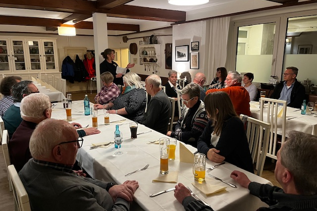 Mehrere Personen sitzen an einem Tisch.